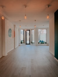 an empty room with wooden floors and windows